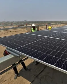 Workers installing a ground-mounted solar array